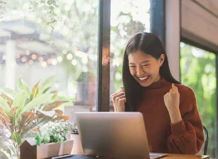 happy woman looking at laptop